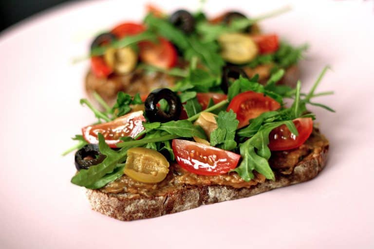Chlebíček s lilkovou tapenádou, cherry rajčaty, rukolou a olivami