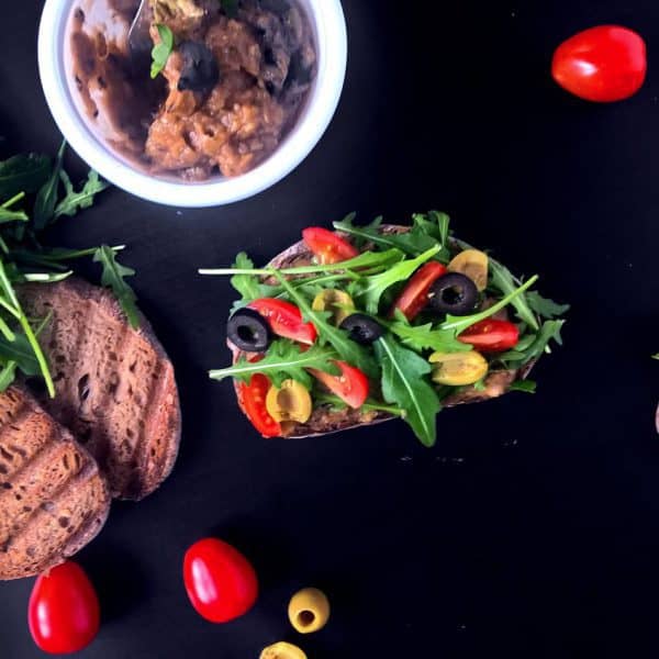 Chlebíček s lilkovou tapenádou, cherry rajčaty, rukolou a olivami